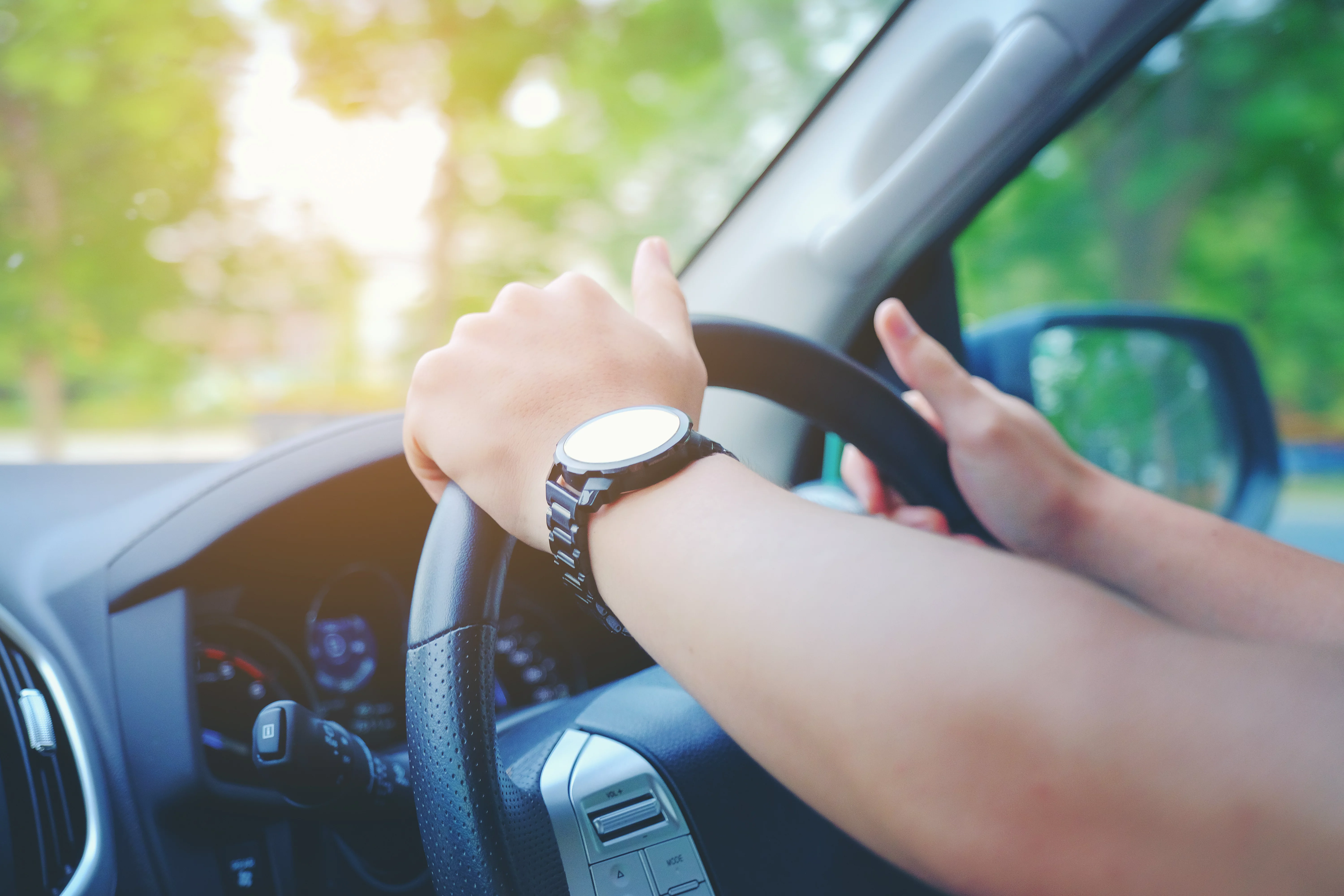 A driver with both hands on the steering wheel.