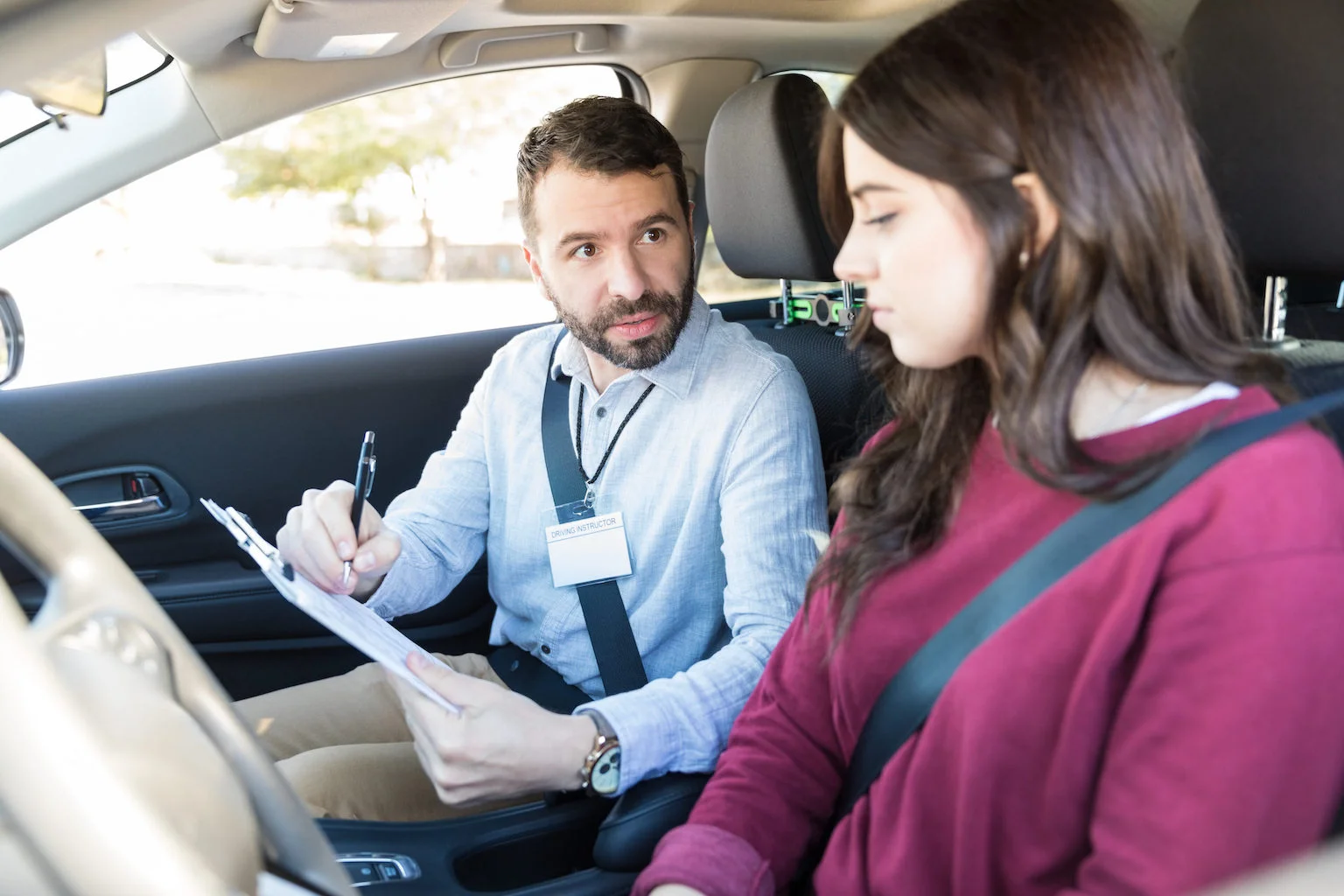 A potential driving instructor explaining a lesson point to his pupil.